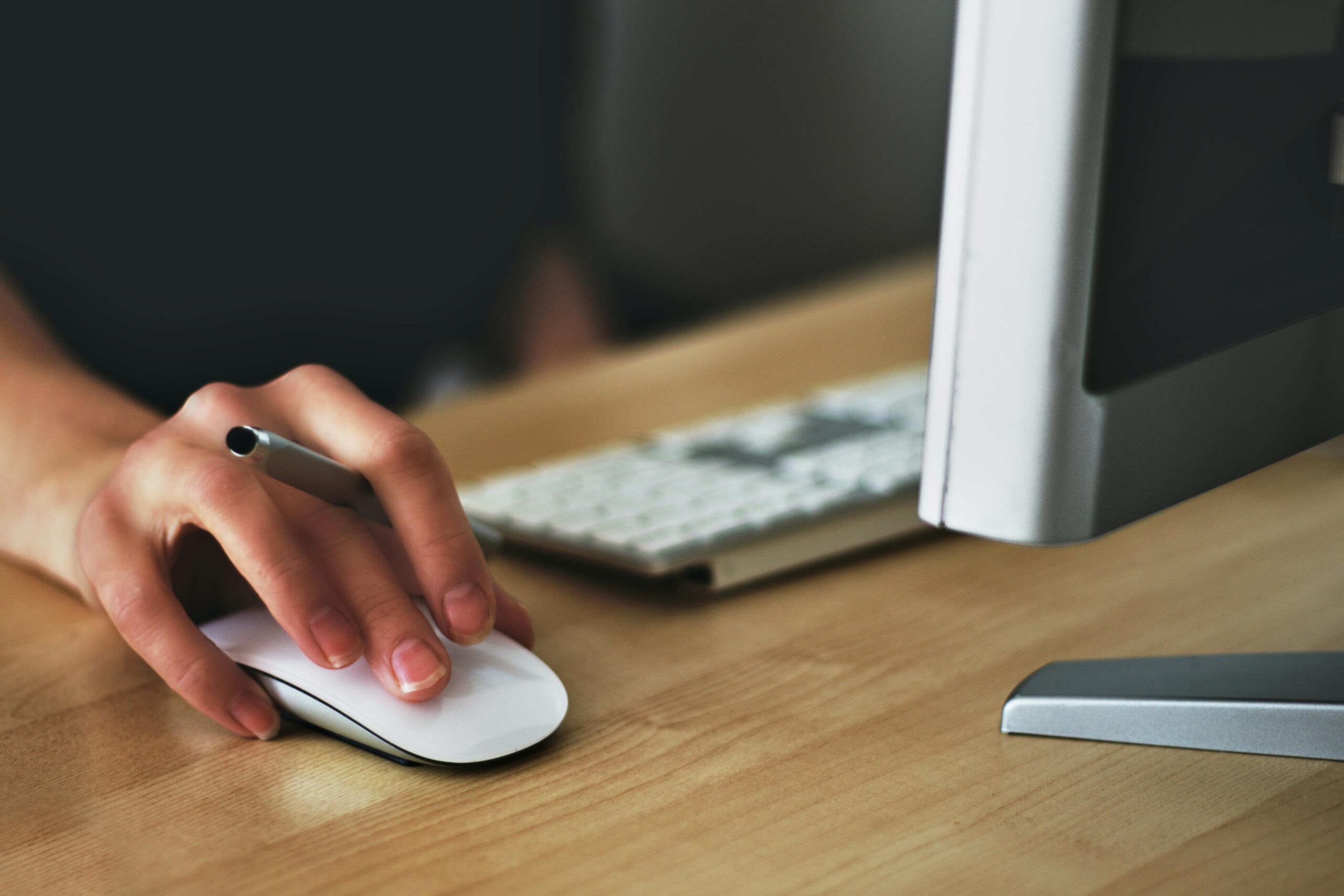 Beyond-Licensing_-How-to-Stop-Wasting-Money-on-Your-Microsoft-365-Security-and-Copilot-Add-Ons-scaled.jpg Free A hand using a wireless mouse at a modern desk setup with a computer and keyboard. Stock Photo
